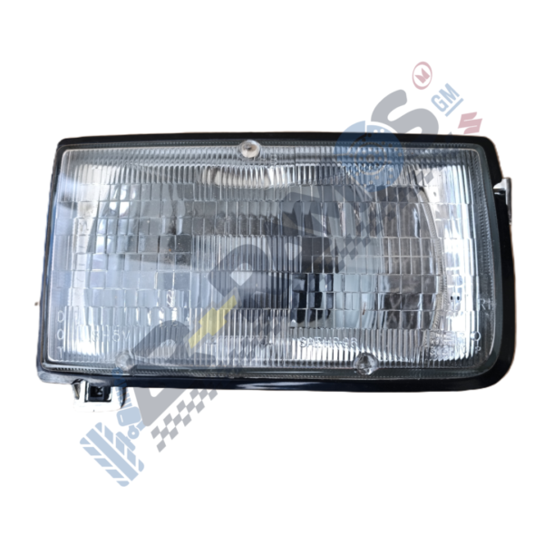 Rectangular car headlight assembly with clear lens and black housing, photographed from front-right side